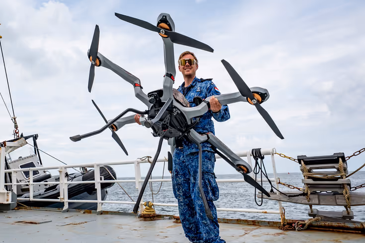Man met drone op het dek van een schip