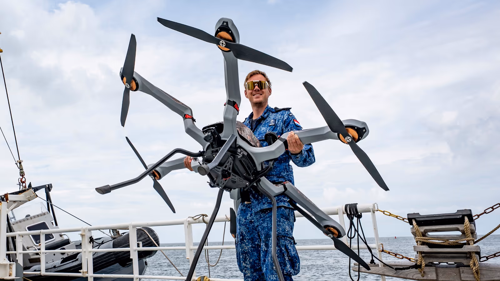 Man met drone op het dek van een schip
