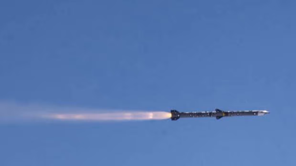 Een vliegende Amraam-raket vanaf de zijkant gezien, met rookpluim erachteraan.