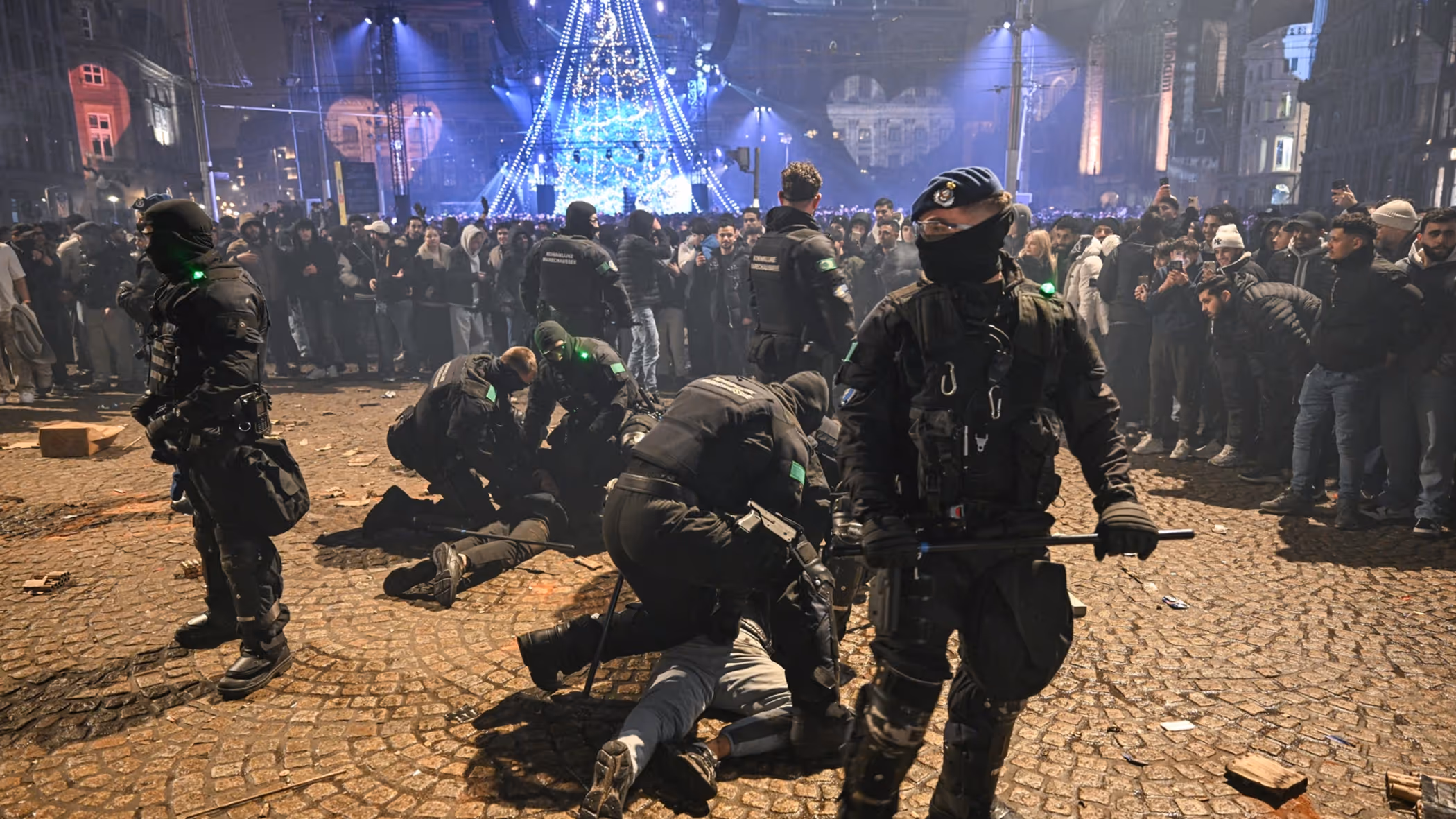 Voertuigen van de ME en politie met mannen met schilden ervoor.