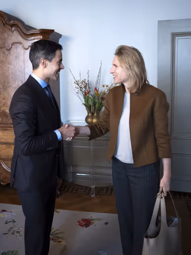 Boekholt-O’Sullivan geeft premier Jetten een hand. Op de andere foto is ze nog te zien in een donker defensie-uniform.