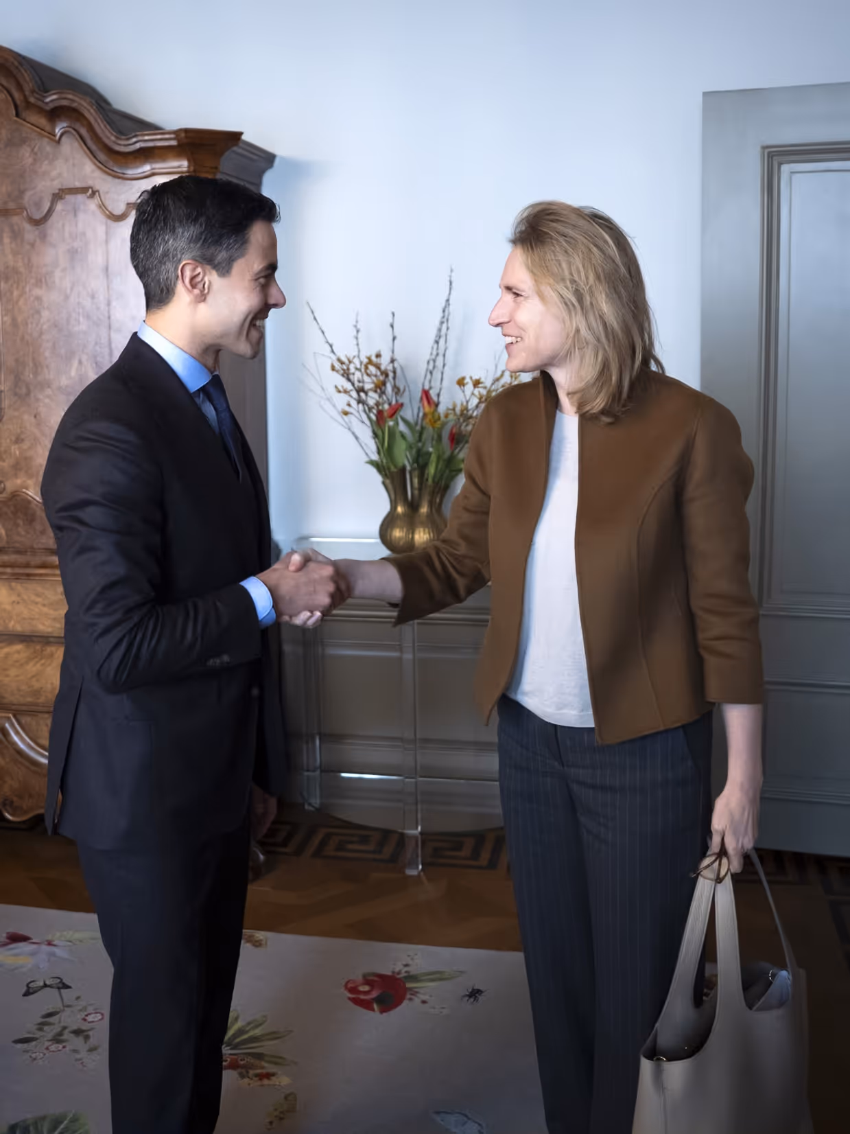 Boekholt-O’Sullivan geeft premier Jetten een hand. Op de andere foto is ze nog te zien in een donker defensie-uniform.