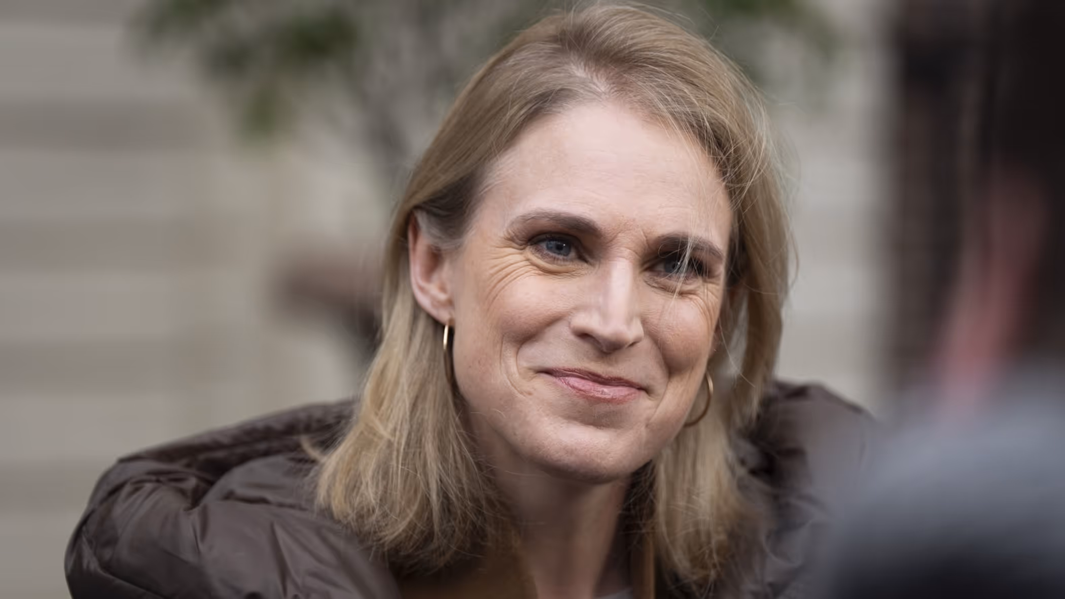 Close-up van minister Boekholt-O’Sullivan in gesprek met journalisten.