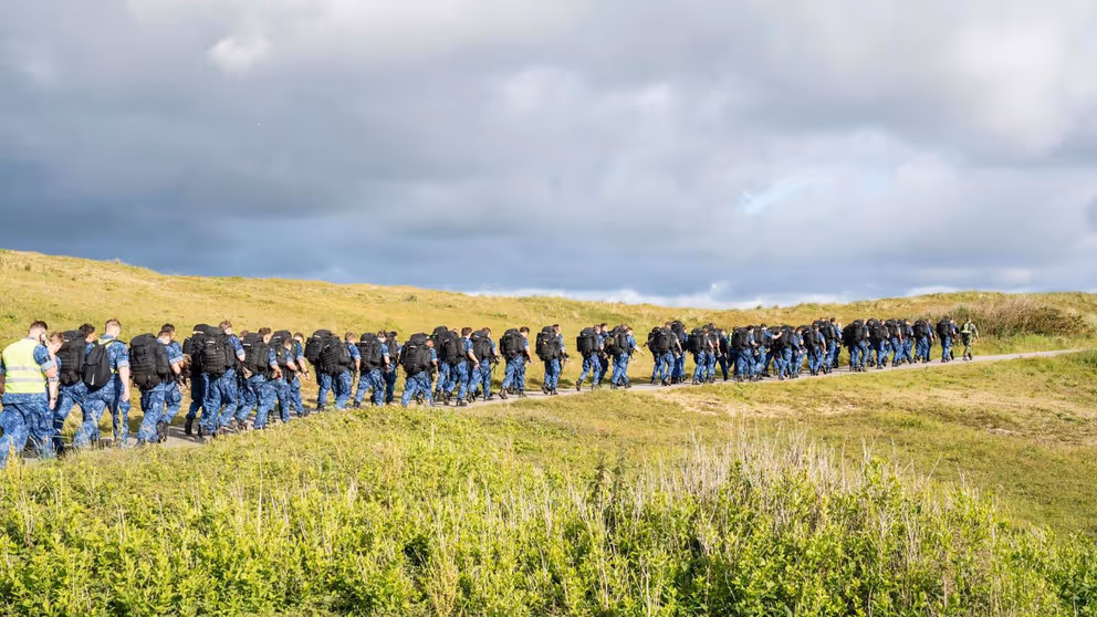 Archieffoto van dienjaarmilitairen die door natuurgebied lopen.