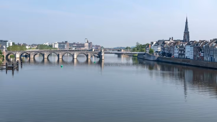 Rivier de Maas stroomt onder oude brug in Maastricht.