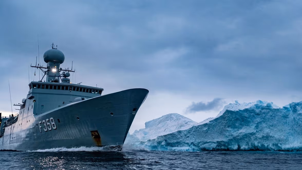 Dilan Yesilgöz tussen militairen bovenop militair voertuig. 