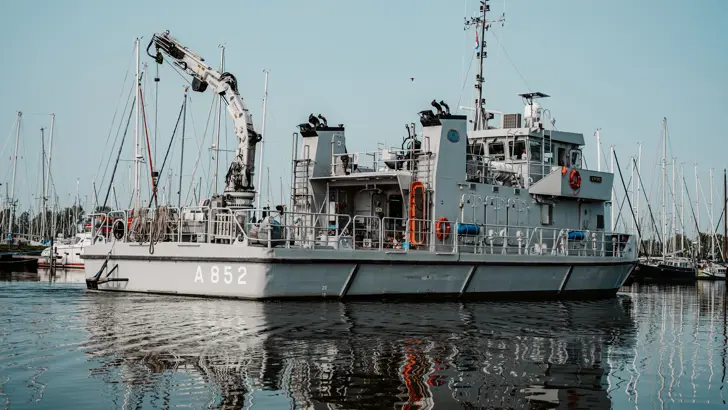 Duikvaartuig de Argus vaart een haven binnen.