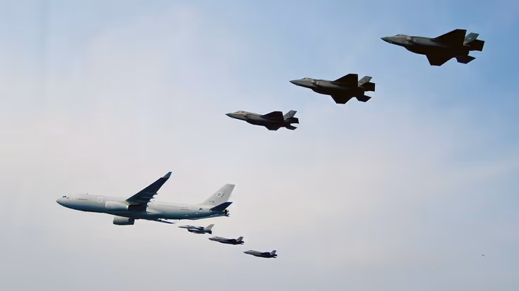 Een formatie die van rechts naar links vliegt, bestaande uit en A330 MRTT met aan de rechter vleugel een Amerikaanse F-16 en een Nederlandse en Japanse F-35. Aan de linker vleugel hangen en een Amerikaanse, Nederlandse en Japanse F-35.