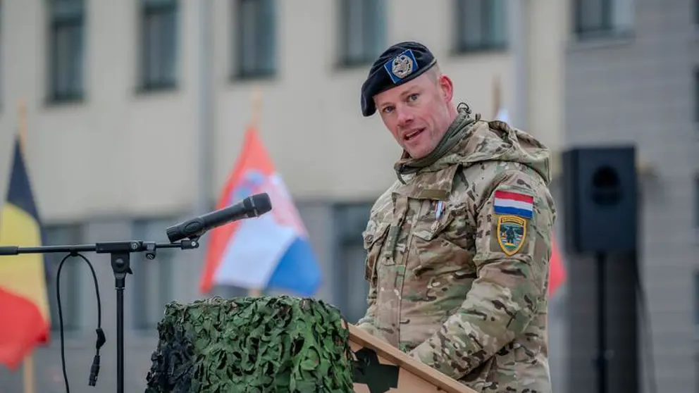 Militair in uniform houdt toespraak achter katheder.