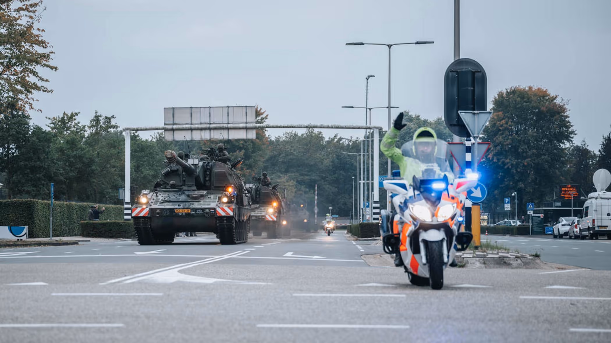 Een motor van de Marechaussee met op de achtergrond voertuigen van de Landmacht.