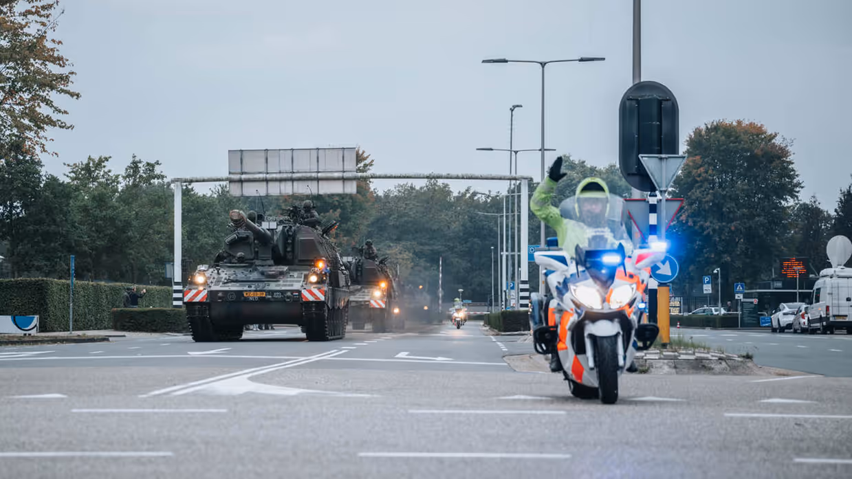 Een motor van de Marechaussee met op de achtergrond voertuigen van de Landmacht.