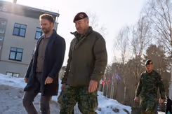 Staatssecretaris Derk Boswijk loopt naast een militair. Op de grond ligt sneeuw.