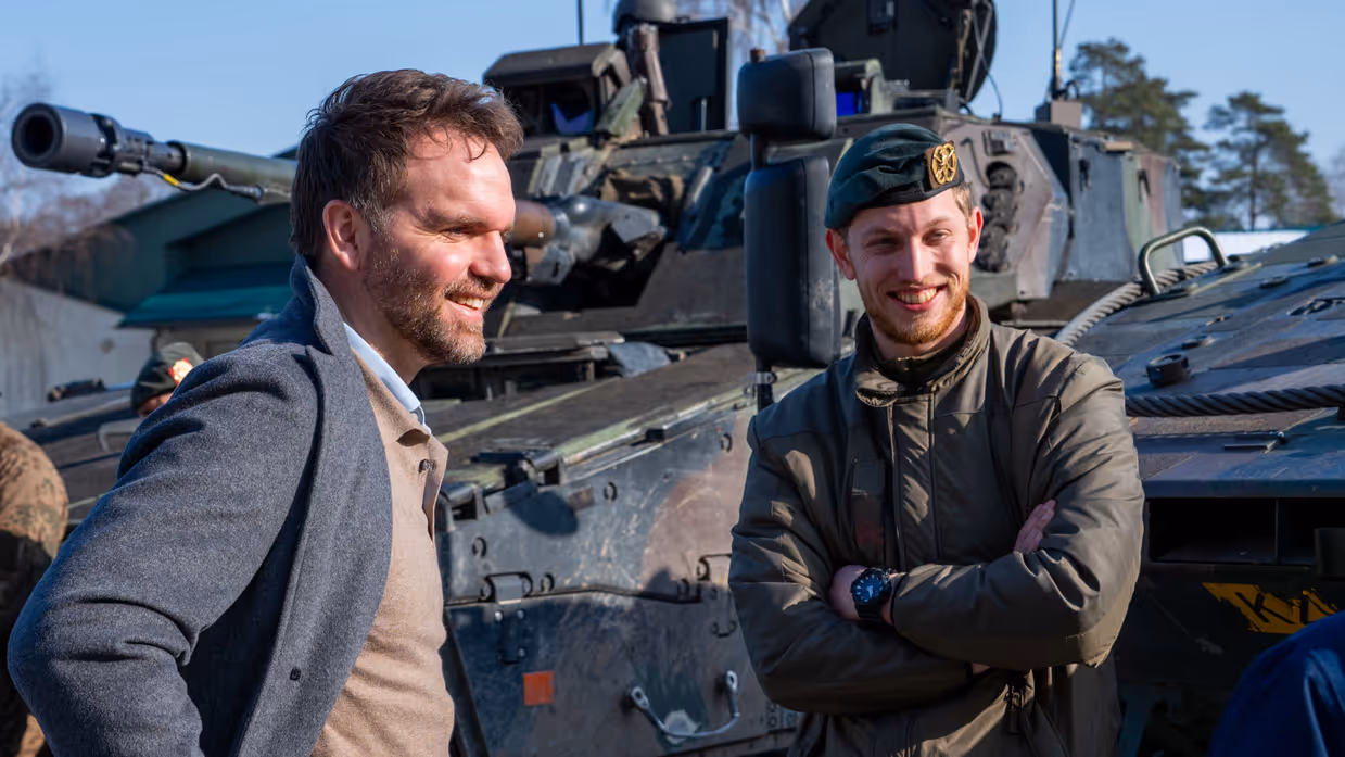 Boswijk staat met de handen in zijn zij en praat met een lachende militair.