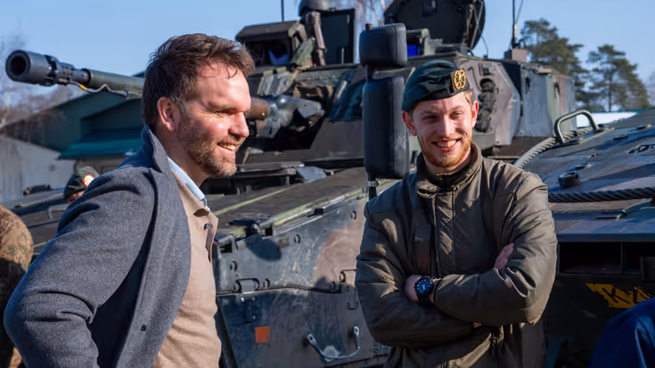 Boswijk staat met de handen in zijn zij en praat met een lachende militair.