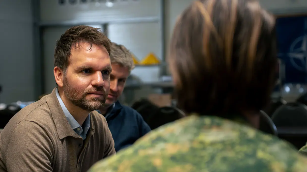 Boswijk luistert naar een militair.