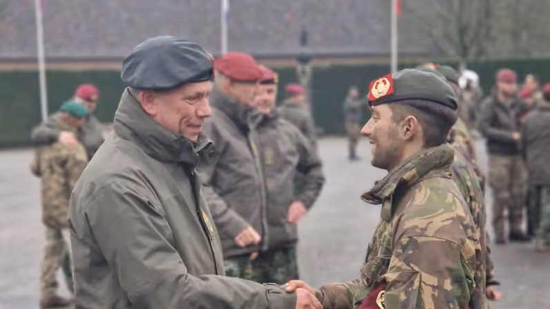 Twee militairen schudden elkaar de hand. 