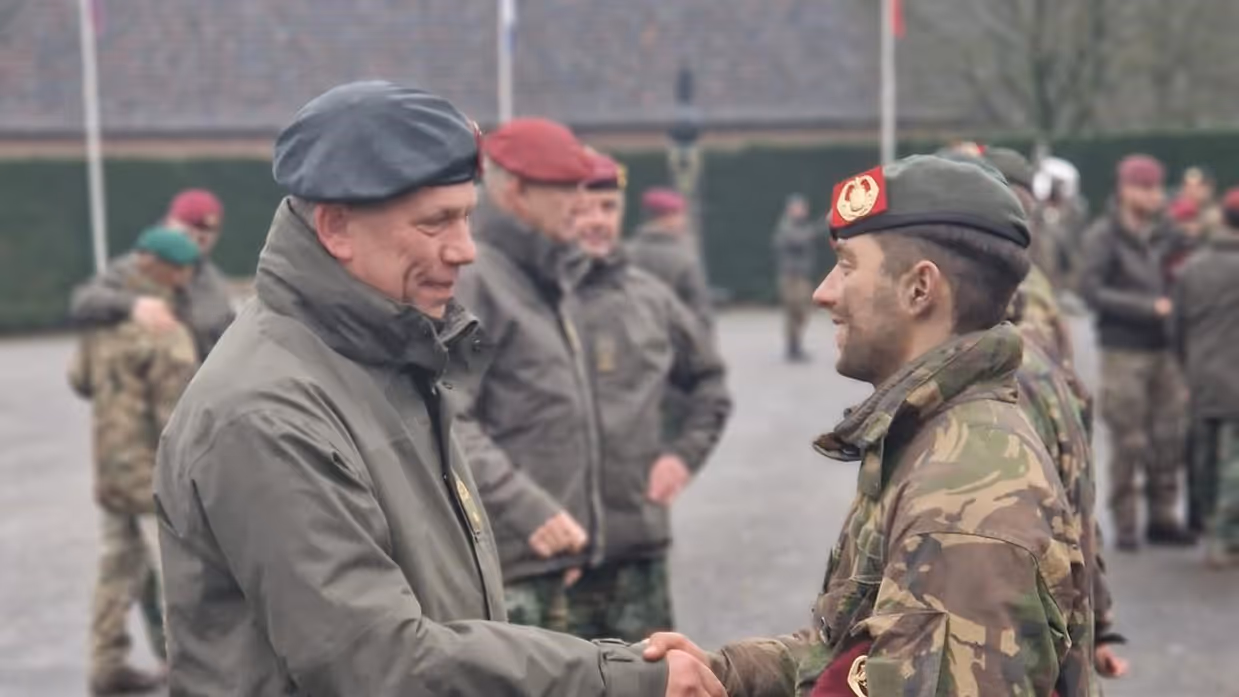 Twee militairen schudden elkaar de hand. 
