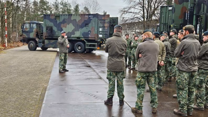 Militairen staan in een groep en praten met elkaar.
