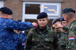 De prinses krijgt ter afronding van haar militaire opleiding bier over haar schouders gegoten.