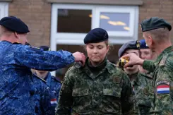 De prinses krijgt ter afronding van haar militaire opleiding bier over haar schouders gegoten.