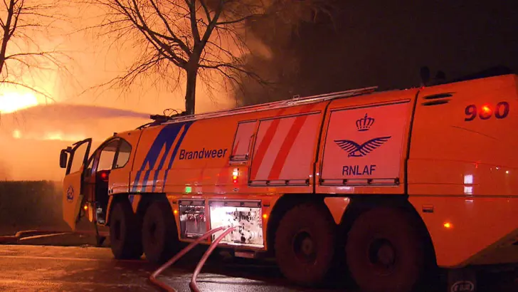 Gele crashtender blust met dakkanon een brand.