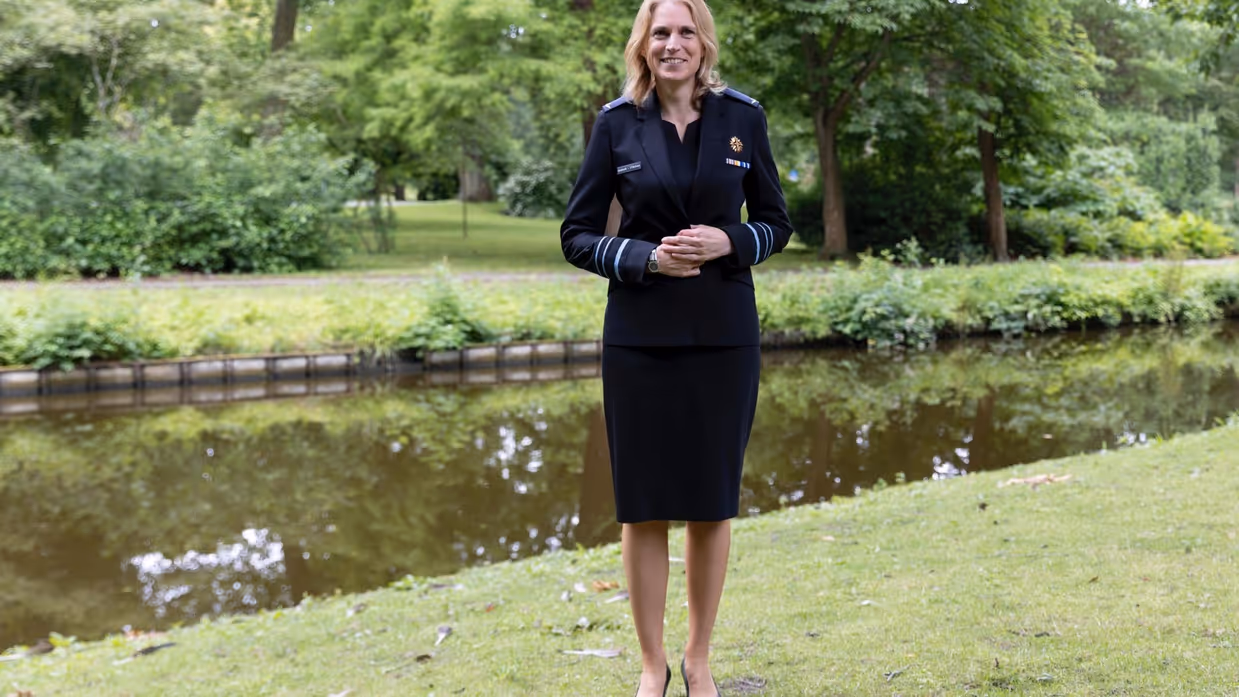 Luitenant-generaal Elanor Boekholt-O’Sullivan poseert in luchtmachtjurk met jasje in parkachtige omgeving.