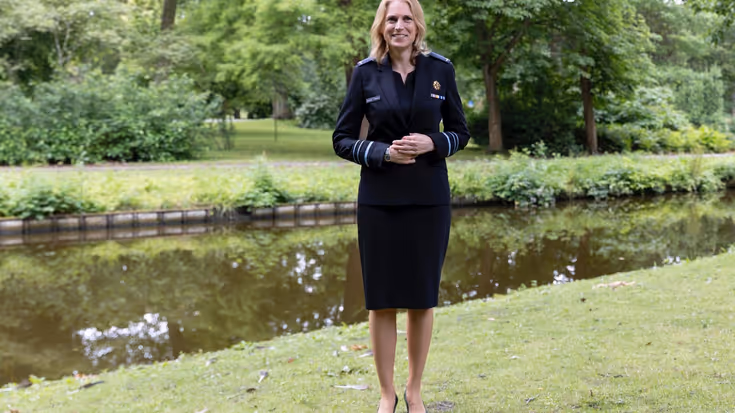 Luitenant-generaal Elanor Boekholt-O’Sullivan poseert in luchtmachtjurk met jasje in parkachtige omgeving.