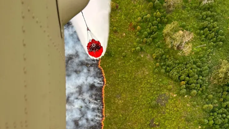 Een Chinook met Bambi Bucket dropt water op de bosbrand op de Hoge Venen