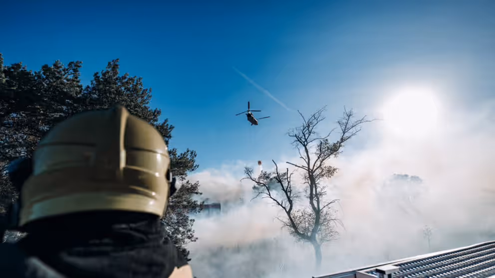 Blushelikopter vliegt boven brand.