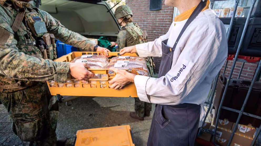 Cateraar levert brood af aan militair.
