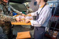 Cateraar levert brood af aan militair.