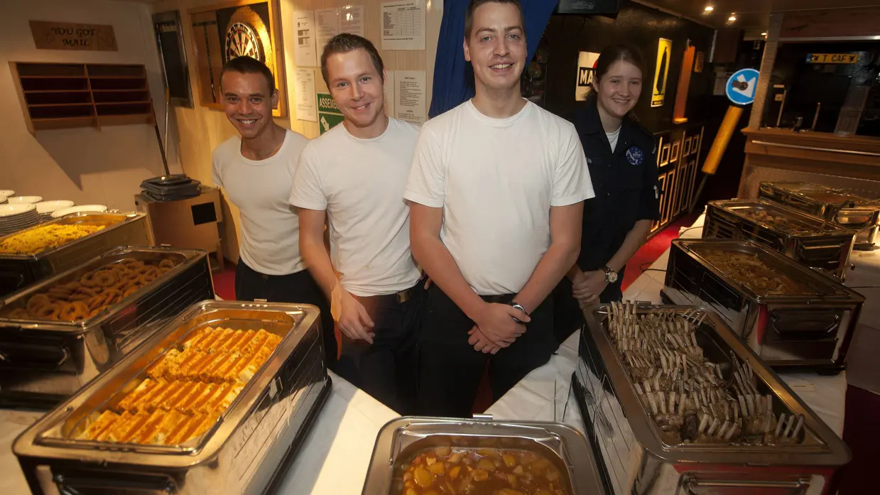 Militairen koks staan in een militairen keuken.