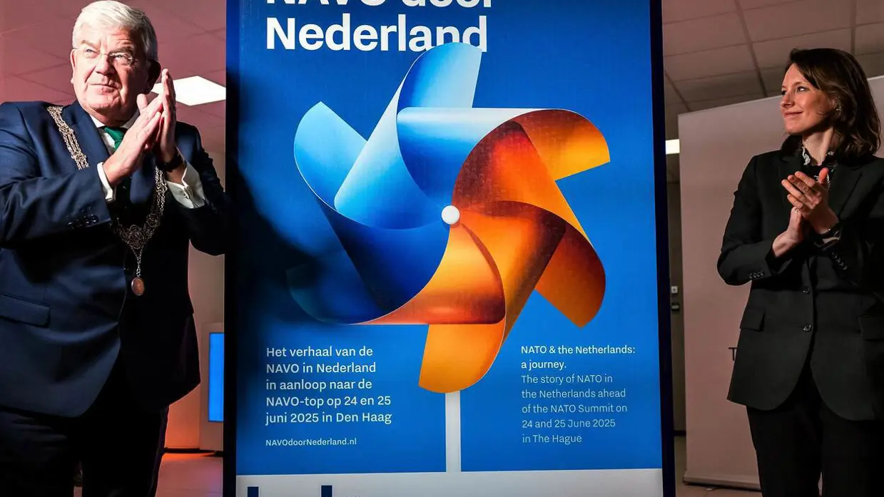 Burgemeester Jan van Zanen van Den Haag (links) en directeur van de Atlantische Commissie Anna van Zoest (rechts) staan voor een banner van de NAVO-tour door Nederland.