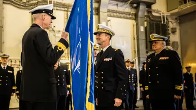Een vaandel wordt overgedragen aan de nieuwe commandant. 