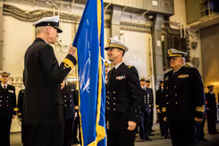 Warnaar op de rug gezien geeft een vlag aan Rear Admiral Joaquin Excagedo.