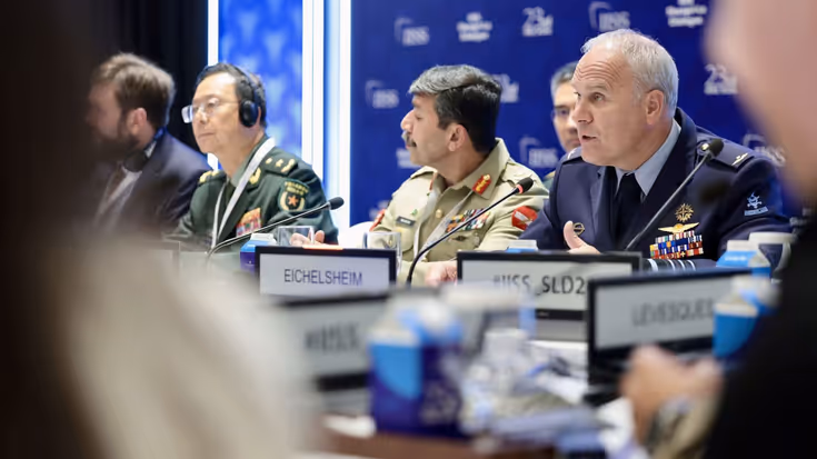 Eichelsheim zit achter een tafel met internationale collega's.