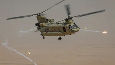 Een Chinook-transporthelikopter die in de lucht flares afschiet. 