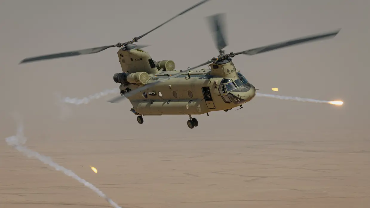 Een Chinook-transporthelikopter die in de lucht flares afschiet. 