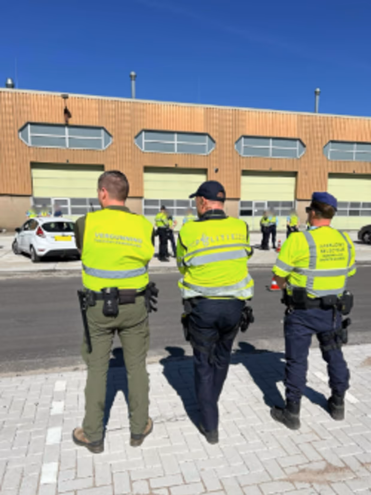 Drie medewerkers van de samenwerkende instanties op de rug gezien.