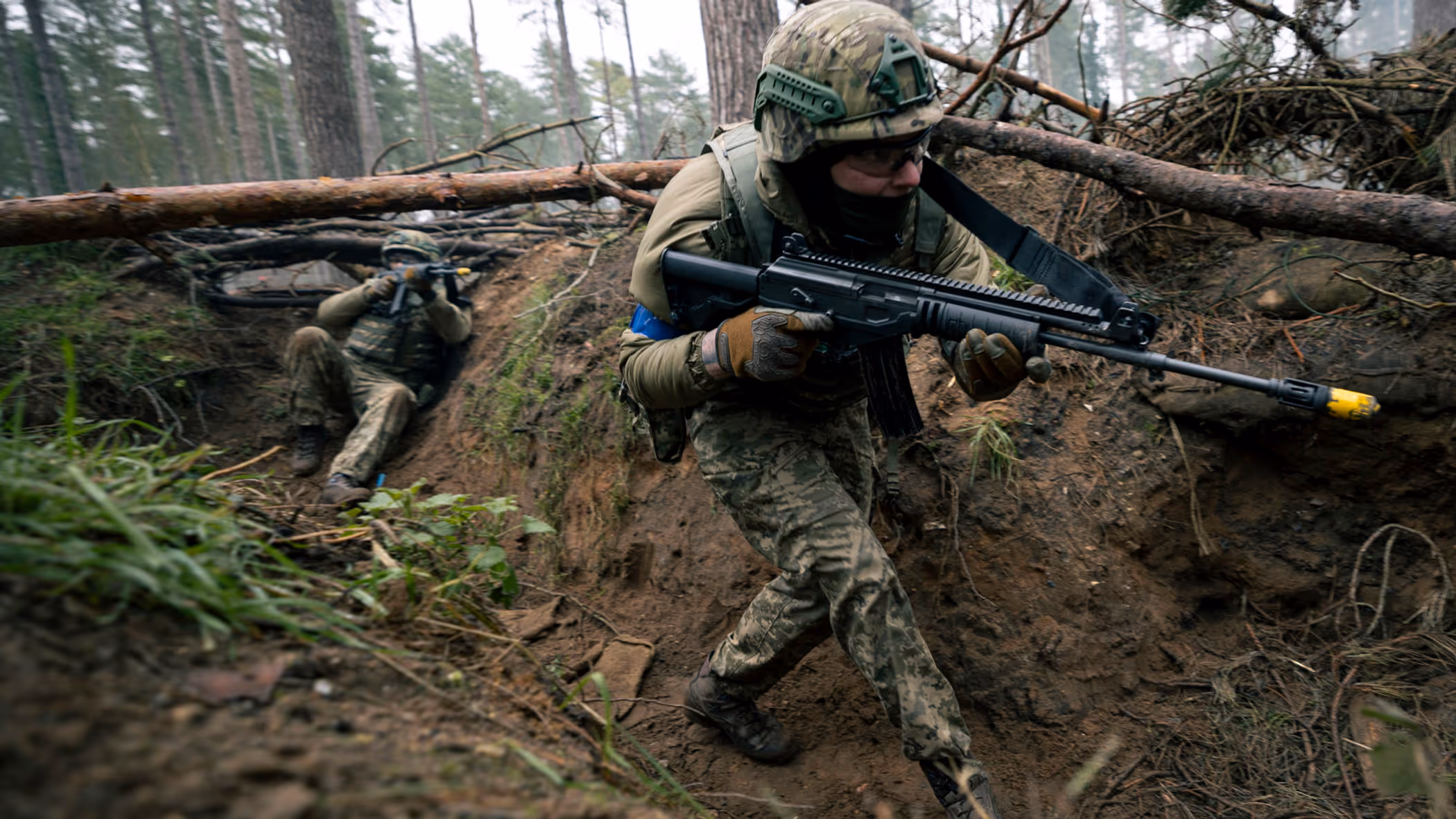 Een militair loopt door een loopgraaf.
