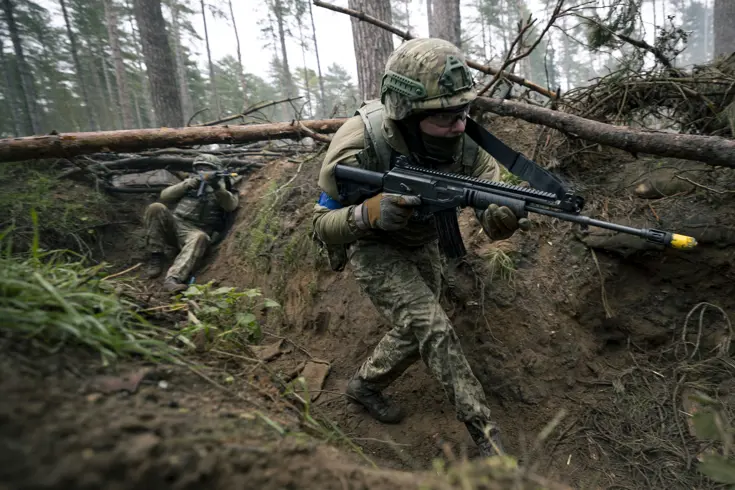 Een militair loopt door een loopgraaf.