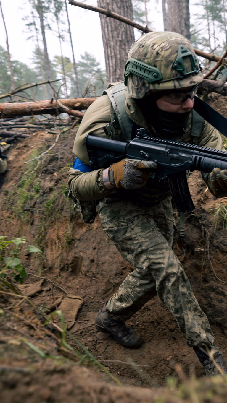 Een militair loopt door een loopgraaf.