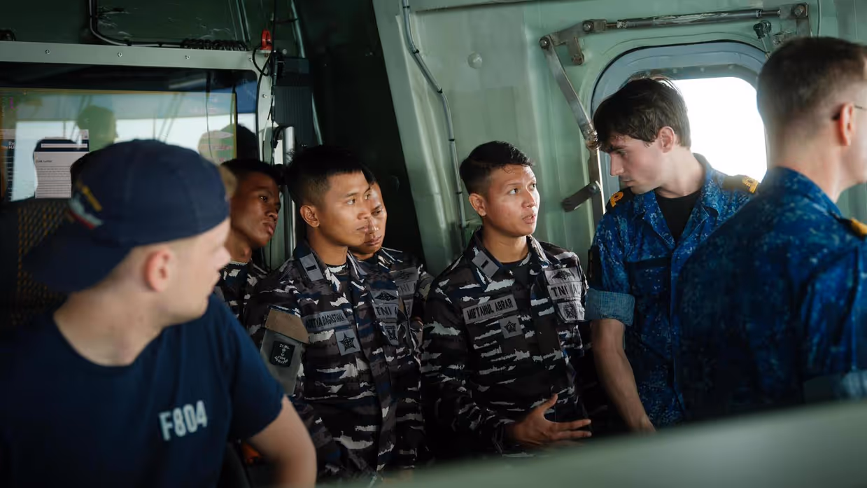 4 Indonesische militairen krijgen een rondleiding op het schip. Zij bevinden zich hier op de brug.