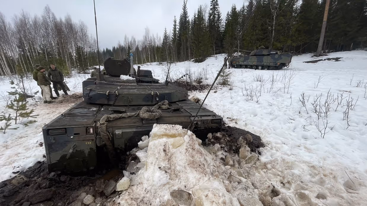 Een militair voertuig steekt boven het ijs uit. Een deel is erdoorheen gezakt.