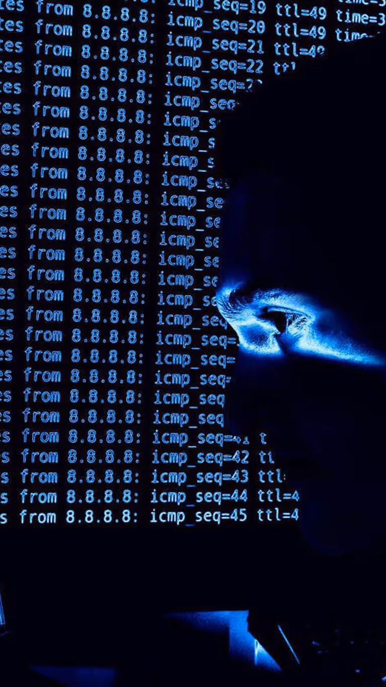 ICT’er in het donker achter computerscherm.