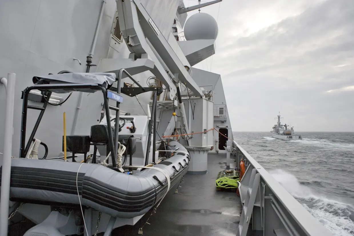 Een RHIB als bijboot aan boord van Zr.Ms. Tromp. Er achter de kraan die de boot in en uit het water takelt. Voor de Tromp vaart Zr.Ms. Van Speijk.