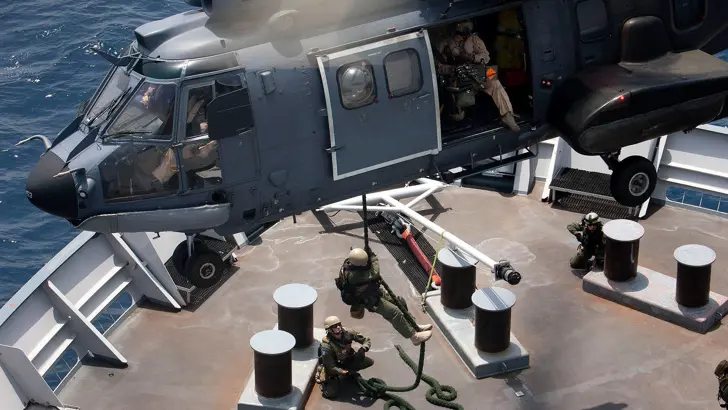 Cougar-transporthelikopter landt op dek marineschip.