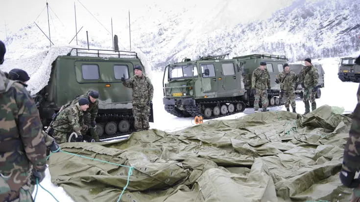 Mariniers zetten tent op in Noorwegen, omringd door Viking-voertuigen.