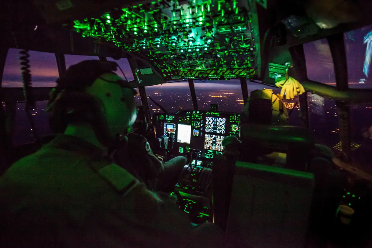 Cockpit met crew in een vliegtuig bij nacht.