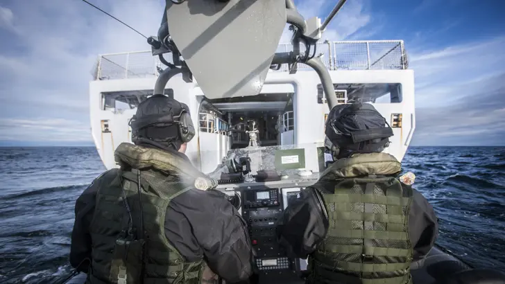 Een Frisc met 2 bemanningsleden vaart het interne dok in van een schip.